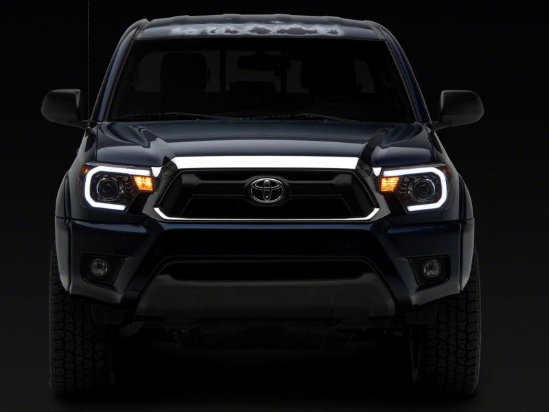 Raxiom 12-15 Toyota Tacoma Axial Projector Headlights w/ SEQL LED Bar- Black Housing (Clear Lens)